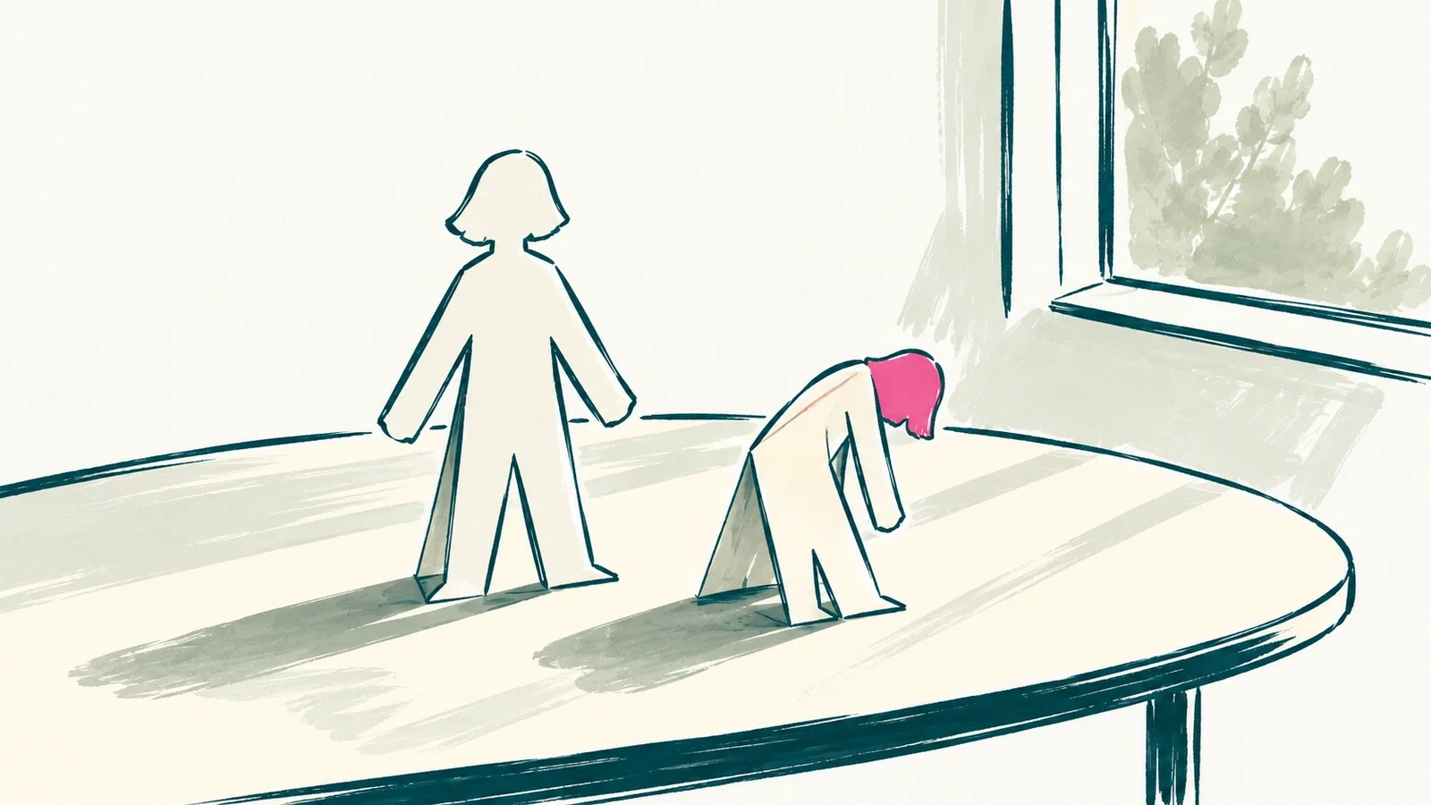 Two paper cutouts of the same figure on a table, one standing upright and one folded over, under soft window light